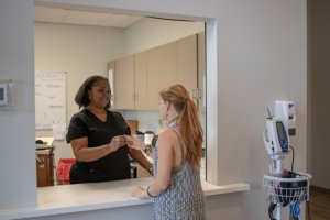 specialist passing vitamins to woman