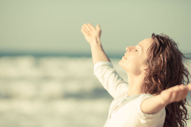 woman with arms open at the beach outside the medical detox center in Virginia.