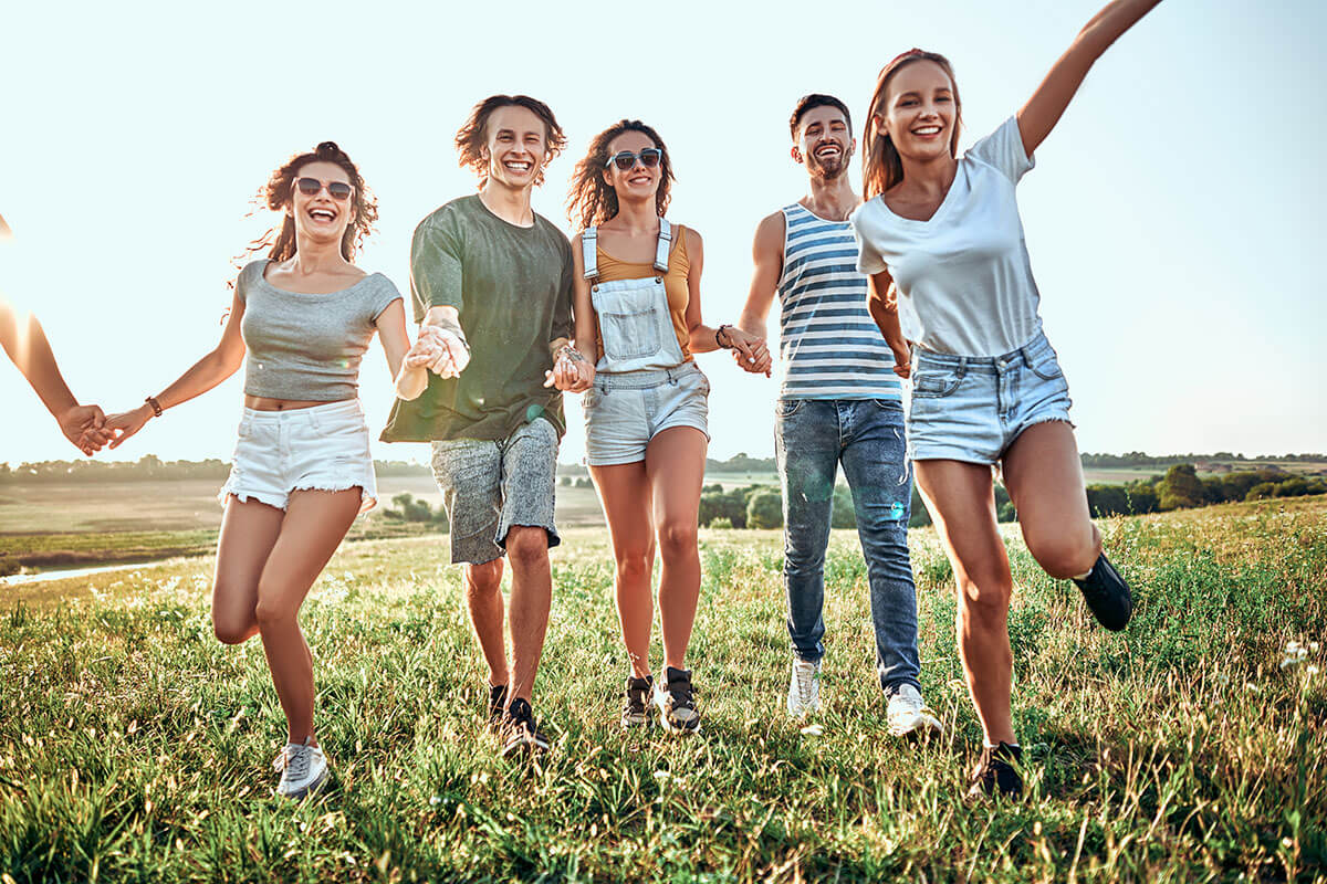 young adults holding hands running through a field outside the medical detox center in Tennessee