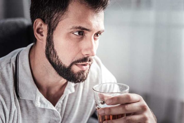 Is There a Connect Between Anxiety and Alcohol_ Man pondering whether there's a connection between anxiety and alcohol