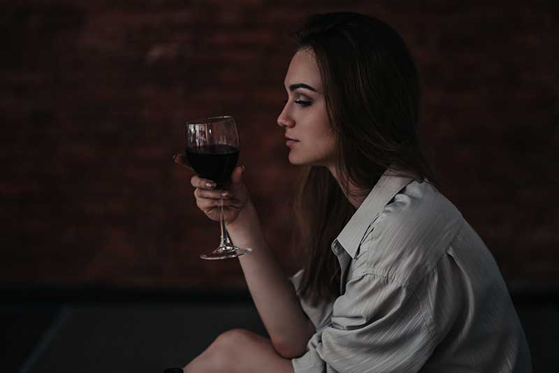 What Are the Dangers of Drinking Alcohol_ Woman pondering the dangers of drinking alcohol