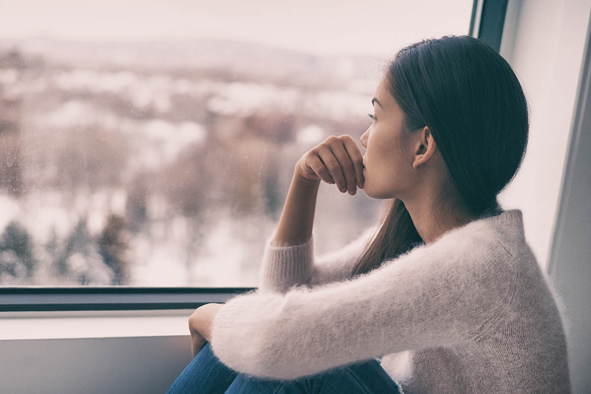 woman staring out window wondering the importance of mental health during detox
