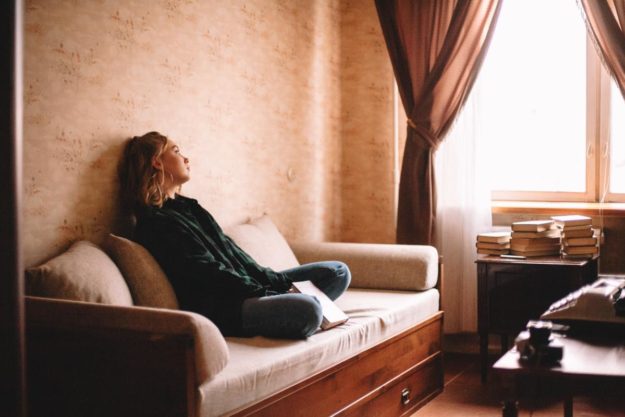 A woman sitting on a couch thinking about alcoholic dementia