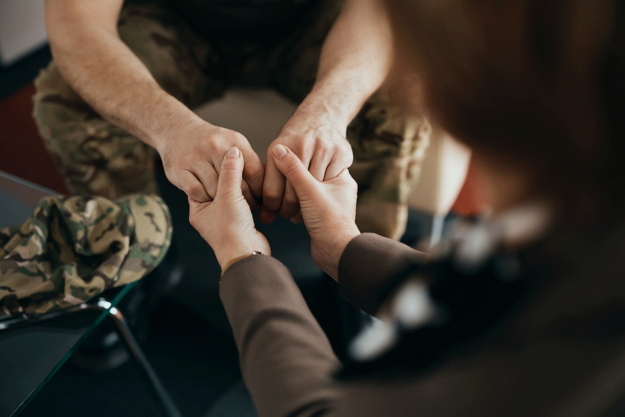 How-To-Help-a-Veteran-with-a-Substance-Addiction Person holding hands with a veteran with a substance addiction
