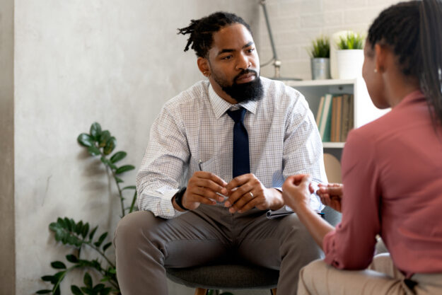 Man sitting and listening to woman speaking