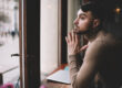 Man looking out window pensive