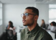 Man with glasses looking off into the distance thinking